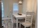 Bright dining room featuring a white table set with seating for four under a modern chandelier at 4205 Quail Ranch Rd, New Smyrna Beach, FL 32168