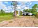 Spacious property featuring a house and detached garage surrounded by green landscaping under a bright sky at 4205 Quail Ranch Rd, New Smyrna Beach, FL 32168