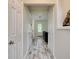 Inviting hallway featuring light wood-look floors leading to a bright living space with a dark sofa at 4205 Quail Ranch Rd, New Smyrna Beach, FL 32168