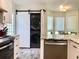 Modern kitchen with a stacked washer and dryer tucked behind a sliding barn door by the dining area at 4205 Quail Ranch Rd, New Smyrna Beach, FL 32168