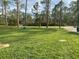 Lush grassy area under tall trees and a sunny sky, perfect for outdoor activities and relaxation at 4205 Quail Ranch Rd, New Smyrna Beach, FL 32168