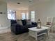 Comfortable living room with a black sofa, modern decor, and tile floors throughout the open concept space at 4205 Quail Ranch Rd, New Smyrna Beach, FL 32168