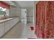 Bright bathroom with a long vanity featuring ample storage, tiled floors, and a decorative shower curtain at 1440 Arroyo Vista Dr, Deland, FL 32724