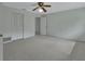 Bright bedroom with neutral walls, carpet, a ceiling fan, and a closet with louvered doors at 1440 Arroyo Vista Dr, Deland, FL 32724