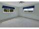 Bright, carpeted bedroom featuring two windows with blue valances, a ceiling fan, and neutral paint at 1440 Arroyo Vista Dr, Deland, FL 32724