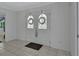 Bright entryway featuring tiled floors, paneled walls and double doors with decorative glass and seasonal wreaths at 1440 Arroyo Vista Dr, Deland, FL 32724