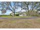 Large home with three car garage situated on a sprawling lawn with a paved driveway and mature landscaping at 1440 Arroyo Vista Dr, Deland, FL 32724