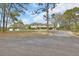 Wide view of home and garage framed by mature trees and a circular driveway at 1440 Arroyo Vista Dr, Deland, FL 32724
