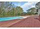 Backyard swimming pool with a wooden deck and wooded scenery at 1440 Arroyo Vista Dr, Deland, FL 32724
