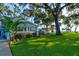 Charming bungalow with a lush front yard, mature trees, and patio at 111 Fleming Ave, Port Orange, FL 32127