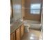 Bathroom features a vanity, toilet, and a bathtub with shower, all with neutral tones and tile at 1110 Deltona Blvd, Deltona, FL 32725