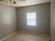 Bright bedroom features tile floors, a window with blinds, ceiling fan, and a neutral color palette at 1110 Deltona Blvd, Deltona, FL 32725