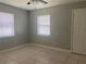 Bright bedroom features tile floors, two windows with blinds, ceiling fan, and a neutral color palette at 1110 Deltona Blvd, Deltona, FL 32725