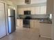 Well-lit kitchen features stainless steel appliances, white cabinets, and tile flooring, blending style and functionality at 1110 Deltona Blvd, Deltona, FL 32725