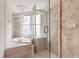 Elegant bathroom featuring a chandelier, soaking tub, and glass-enclosed shower with marble-style tile at 3703 S Atlantic Ave # 501, Daytona Beach Shores, FL 32118