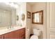 Traditional-style bathroom featuring wooden vanity with sink, a toilet, and decorative framed mirrors at 3703 S Atlantic Ave # 501, Daytona Beach Shores, FL 32118