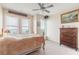 Bedroom with plush carpet, an antique-style bed frame, windows with blinds, and decorative artwork at 3703 S Atlantic Ave # 501, Daytona Beach Shores, FL 32118