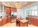 Bright kitchen features wooden cabinetry, granite countertops, stainless steel refrigerator, and an island with sink at 3703 S Atlantic Ave # 501, Daytona Beach Shores, FL 32118