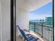 Balcony view of the beach and pool below features two lounge chairs and small table at 2555 S Atlantic Ave # 207, Daytona Beach Shores, FL 32118