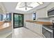 Bright kitchen with stainless steel appliances, tile flooring, and direct access to outdoor balcony at 2555 S Atlantic Ave # 207, Daytona Beach Shores, FL 32118