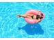 Aerial view of a Personal relaxing on a pink pool float in a bright blue swimming pool at 2555 S Atlantic Ave # 207, Daytona Beach Shores, FL 32118