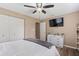 This cozy bedroom features a ceiling fan, TV, closet, and white dresser at 114 Palm Dr, Daytona Beach, FL 32117