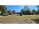 Large backyard with a playset, mature trees, and plenty of room for outdoor activities and entertainment at 250 Hickory Ave, Orange City, FL 32763