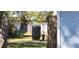 View of a backyard showing the water conditioning equipment, fencing, and sparse groundcover at 250 Hickory Ave, Orange City, FL 32763