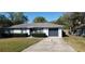 Charming single-story home with gray siding, manicured hedges, and a well-maintained front yard at 250 Hickory Ave, Orange City, FL 32763