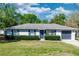 Charming front exterior with lush greenery, a well-maintained lawn, and an attached two-car garage at 250 Hickory Ave, Orange City, FL 32763