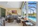Relaxing sunroom with pool view, comfortable seating, and fire pit at 9777 Sw 63Rd Loop, Ocala, FL 34481
