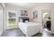 Bedroom with wood-look floors, white walls, artwork, and a window overlooking the backyard at 2126 7Th Ave, Deland, FL 32724