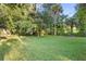 Large green backyard, partially shaded by trees, in a sunny neighborhood at 522 Powers Ave, Port Orange, FL 32127