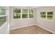 Cozy bedroom with light wood flooring and natural light from two windows at 522 Powers Ave, Port Orange, FL 32127