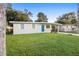 Charming single-story home featuring a well-maintained lawn, a vibrant blue door, and a covered parking area at 522 Powers Ave, Port Orange, FL 32127