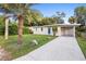 Inviting single-story home with a blue door and adjacent carport set on a well-manicured lawn at 522 Powers Ave, Port Orange, FL 32127