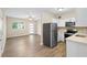 Open-concept kitchen and living area with stainless steel appliances and light wood-look flooring at 522 Powers Ave, Port Orange, FL 32127