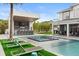 Lush backyard featuring a pool, spa, outdoor kitchen, and ample seating areas for entertaining at 4 Broad Creek Cir, Ormond Beach, FL 32174