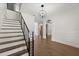Bright foyer featuring hardwood floors, stairs with modern black railing, and elegant chandelier at 4 Broad Creek Cir, Ormond Beach, FL 32174