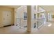 Hallway featuring a door, white railings, and building facade on the outside at 4650 Links Village Dr # C303, Ponce Inlet, FL 32127
