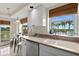 Well-lit kitchen with white cabinetry, stainless appliances, and a view of lush greenery at 4650 Links Village Dr # C303, Ponce Inlet, FL 32127