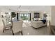 Bright living room features an open floor plan, tile floors, a dining table, and access to a private balcony at 4650 Links Village Dr # C303, Ponce Inlet, FL 32127