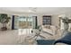 Bright living room features an open floor plan, tile floors, and access to a private balcony overlooking manicured grounds at 4650 Links Village Dr # C303, Ponce Inlet, FL 32127
