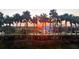 Panoramic sunset view between palm trees showcasing the surrounding green spaces, buildings, and landscaping at 4650 Links Village Dr # C303, Ponce Inlet, FL 32127