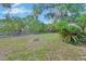 Expansive backyard featuring lush grass, a fire pit, and bordered with mature trees at 532 W Wisconsin Ave, Deland, FL 32720