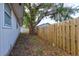Home's backyard with wooden fence and mature tree at 119 Bigelow Dr, Edgewater, FL 32132