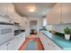 Bright kitchen with white cabinetry, green countertops, and a view of a dining area at 119 Bigelow Dr, Edgewater, FL 32132
