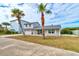 Two-story house with gray siding, palm trees, and a brick driveway at 4766 S Atlantic Ave, Ponce Inlet, FL 32127