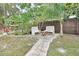 Landscaped backyard with brick patio and two white benches at 714 E Michigan Ave, Deland, FL 32724