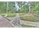 Expansive backyard featuring a stone walkway, mature trees, and plenty of room for outdoor activities at 714 E Michigan Ave, Deland, FL 32724